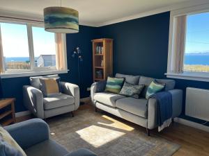 a living room with a couch and two chairs at Buaile nan Carn in Kilmuir