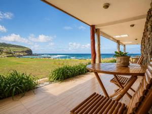 a porch with a table and a view of the ocean at Cabañas & Hostal Tojika in Hanga Roa