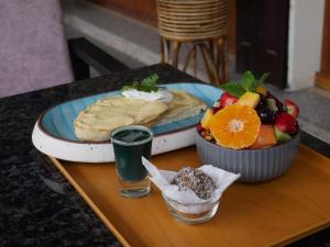 a table with a plate of food and a bowl of fruit at Kalash Parkaze Glamping Hostel in Pokhara