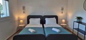 a bedroom with two beds with pillows and two lamps at Apartment K2 in Pyrgi