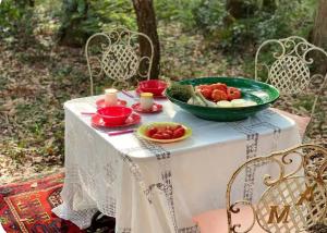 a table with a bowl of tomatoes and candles on it at Roulotte de luxe avec piscine partagée à Ramatuelle in Ramatuelle
