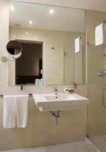 a bathroom with a sink and a shower and a mirror at TURIM Restauradores Hotel in Lisbon
