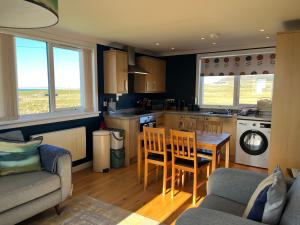 a kitchen with a table and chairs in a room at Buaile nan Carn in Kilmuir