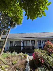 an old house with a palm tree and flowers at The Old Library in Arisaig