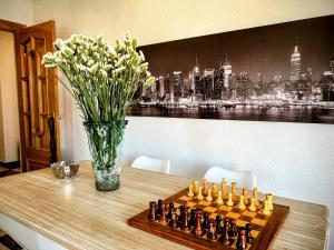 a chess board on a table with a vase of flowers at Íberos Royal in La Zubia
