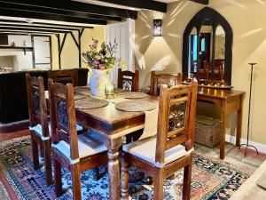 a dining room table and chairs with a vase of flowers at Sunnybrae Cottage in Tintagel