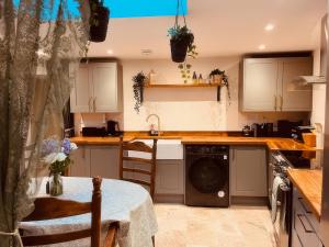 a kitchen with a dishwasher in the middle at Sunnybrae Cottage in Tintagel +40 photos