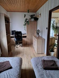 a room with two beds and a desk with a chair at Pension Renata in Šediviny