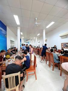 a group of people sitting at tables in a restaurant at Khách Sạn Mai Hà Sầm Sơn in Sầm Sơn