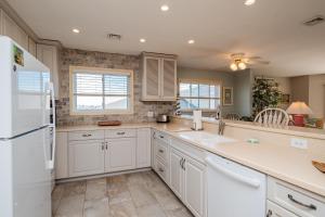a kitchen with white cabinets and a white refrigerator at Fish Tales by Oak Island Accommodations in Oak Island