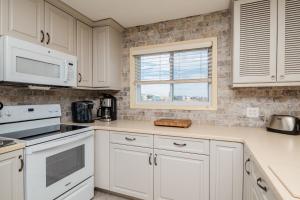 a kitchen with white cabinets and a window at Fish Tales by Oak Island Accommodations in Oak Island