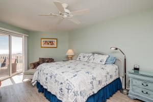 a bedroom with a bed and a ceiling fan at Fish Tales by Oak Island Accommodations in Oak Island