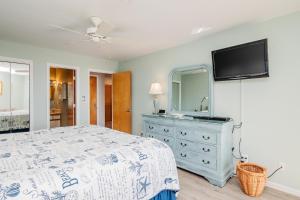 a bedroom with a bed and a dresser with a mirror at Fish Tales by Oak Island Accommodations in Oak Island
