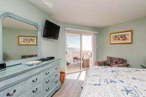 a bedroom with a dresser with a mirror at Fish Tales by Oak Island Accommodations in Oak Island +47 photos