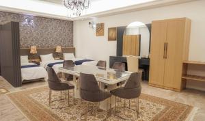 a living room with a dining table and a bedroom at Motel Victoria Sky in Erbil