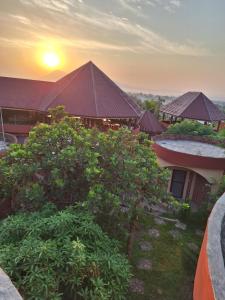 a view of a building with a sunset in the background at MANGALA Hotel BIO in Palimé