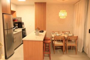 a kitchen with a table and chairs and a refrigerator at MHV Milagres - Curimã B 1 in Passo de Camarajibe