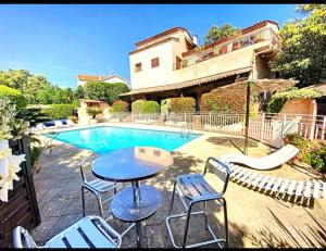 a patio with a table and chairs next to a pool at Casa Louca in Saint-Aygulf