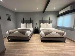 a bedroom with two beds and a window at Origen in San Miguel de Allende