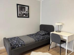 a bed in a room with a desk and a chair at Apartament Rodzinny - Classic Olszowa - in Włocławek