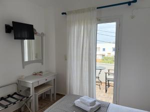 a bedroom with a bed and a desk and a window at 9 Muses in Elafonisos