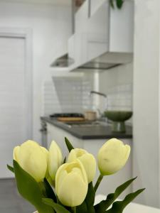 a vase filled with yellow flowers in a kitchen at Casa Carolina Cinisi in Cinisi