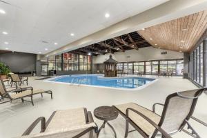 a pool in a hotel lobby with chairs and tables at Best Western Braddock Inn in La Vale