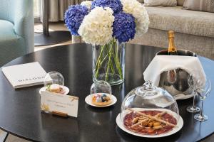 a table with a bottle of wine and a plate of food at VP Plaza España Design in Madrid
