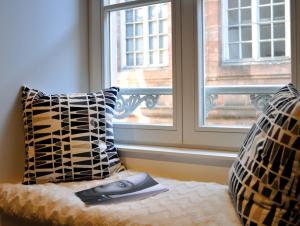 une télécommande assise sur un lit devant une fenêtre dans l'établissement Appartement L'Ill au Sable, à Strasbourg