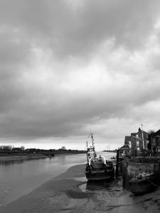 two boats are docked on the shore of a river at Bedroom 2 with a little loo in King's Lynn +3 photos