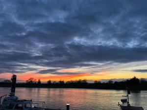 a sunset over a body of water with a lighthouse at Bedroom 2 with a little loo in King's Lynn