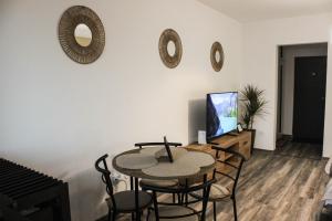 a living room with a table and chairs and a tv at Soarelui Cozy Studio in Braşov