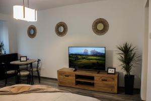 a living room with a flat screen tv on a dresser at Soarelui Cozy Studio in Braşov