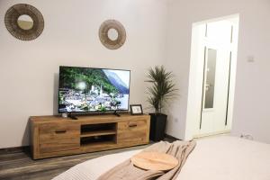 a bedroom with a flat screen tv on a wooden dresser at Soarelui Cozy Studio in Braşov