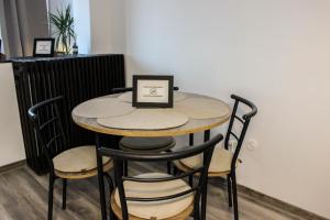 a table with chairs and a laptop on top of it at Soarelui Cozy Studio in Braşov +17 photos