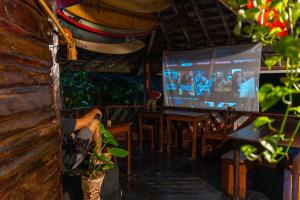 a person sitting at a table watching a screen at Beach House NATUREZA self check-in in Itacaré