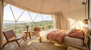 a bedroom with a bed and a large window at Bubble Glam I Poggetti in Micciano