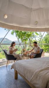 a man and woman sitting at a table in a bedroom at Bubble Glam I Poggetti in Micciano