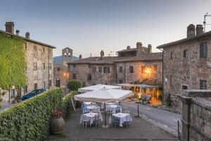 a patio with tables and umbrellas in an old building at Bubble Glam I Poggetti in Micciano