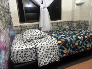 a bed with two pillows sitting next to a window at Departamento con parqueadero céntrico in Baños