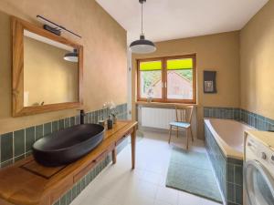 a bathroom with a black bath tub and a sink at KUNSTapARTment in Kallmünz +28 photos