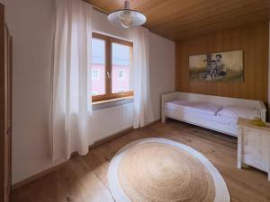 a room with a bed and a window and a rug at KUNSTapARTment in Kallmünz