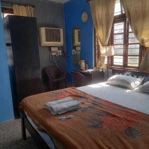 a bedroom with a bed with two towels on it at THUBE Saheb B&B in Jabalpur