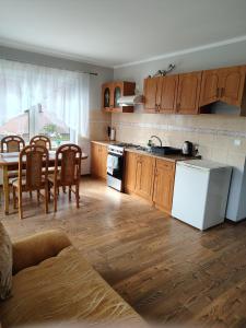 a kitchen with wooden cabinets and a table and chairs at Apartament Wisełka nad jeziorem in Wisełka