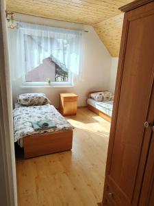 a small bedroom with two beds and a window at Apartament Wisełka nad jeziorem in Wisełka
