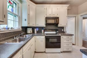 a kitchen with white cabinets and a sink at Private Deck & Yard: Pet-Friendly Noble Getaway in Noble