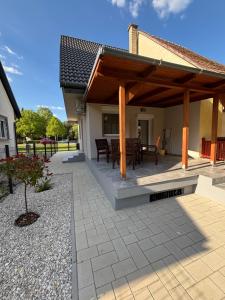 a patio with a wooden pergola at JanBar Apartman in Bük