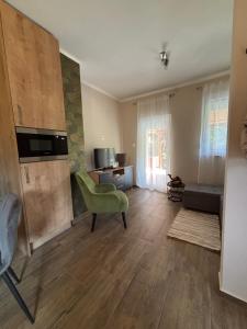 a living room with a green chair and a couch at JanBar Apartman in Bük +8 photos