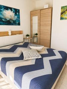 a bedroom with two beds with blue and white sheets at Ninfa del lago - PRIVATE GARAGE in Colico