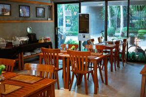a dining room with wooden tables and chairs at Blue River Resort in Phitsanulok